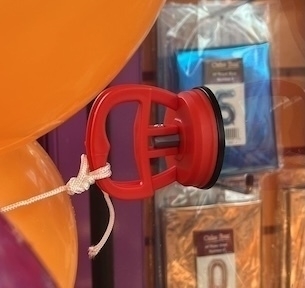 Suction cups on glass shop front to support balloon arch